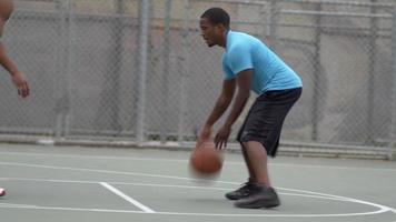 zwei junge Männer, die eins gegen eins Basketball gegeneinander spielen. video