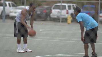 een jonge basketbalspeler die een dunk mist terwijl hij één op één speelt. video