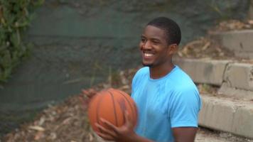 Retrato de un joven jugador de baloncesto que pasa el balón a un amigo que llega a las canchas.