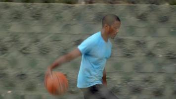 een jonge basketbalspeler die dribbelt voordat hij de bal doorgeeft aan een teamgenoot.