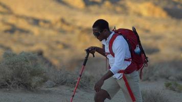 un jeune homme faisant de la randonnée dans un désert montagneux.