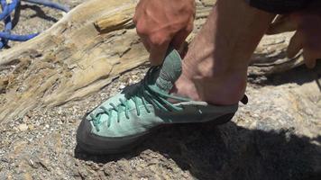 Detalle de un hombre poniéndose sus zapatos de escalada. video