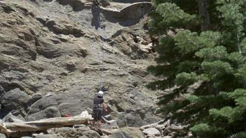 ein junger Mann, der beim Klettern einen Berg abstößt.