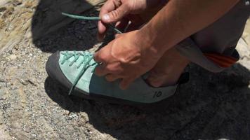 detalhe de um homem calçando seus sapatos de escalada.