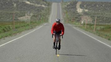 um homem andando de bicicleta em uma estrada panorâmica.