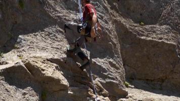 um alpinista caindo e sendo salvo por sua corda. video