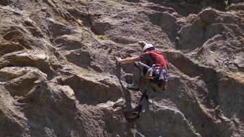 un giovane che si arrampica su una montagna. video