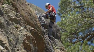 A young man rock climbing on a mountain.