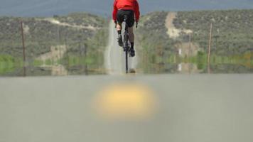 um homem andando de bicicleta em uma estrada cênica no deserto. video