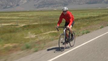 un hombre en bicicleta por una carretera escénica. video