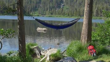 An empty hammock near a mountain lake. video