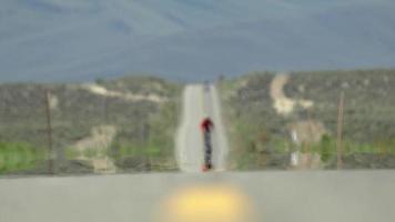 um homem andando de bicicleta em uma estrada cênica no deserto. video