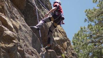 Eine Frau sichert einen Mann beim Klettern. video