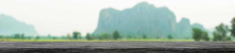 Tablero de madera panorámica con paisaje natural fondo borroso vista frontal vacía para mostrar el producto el estilo de la naturaleza verde foto