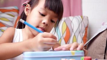 fofo criança pré-escolar desenhando e colorindo em casa, fique em casa durante o surto de coronavírus. conceito de educação escolar em casa. video
