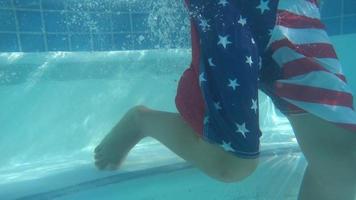 um menino descendo as escadas em uma piscina em um resort de hotel. video