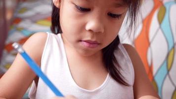 fofo criança pré-escolar desenhando e colorindo em casa, fique em casa durante o surto de coronavírus. conceito de educação escolar em casa. video