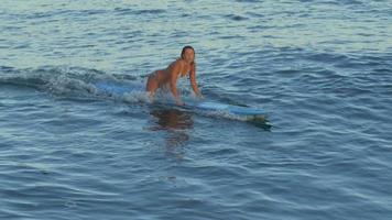 uma jovem surfando de biquíni em uma prancha de surfe longboard.