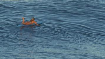 eine junge Frau, die im Bikini auf einem Longboard-Surfbrett surft. video