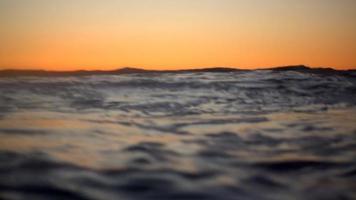 golven breken in de Stille Oceaan bij zonsondergang. video