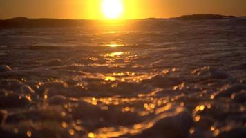 ondas quebram no oceano pacífico ao pôr do sol. video