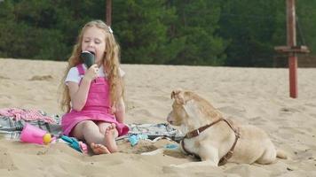 niña come helado y alimenta al perro al aire libre video