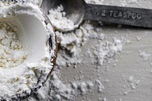 Close Up of a Wooden Bowl of Flour with a Metal Teaspoon photo