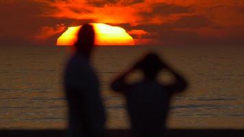 silhuett av en man som tittar på solnedgången på stranden. video