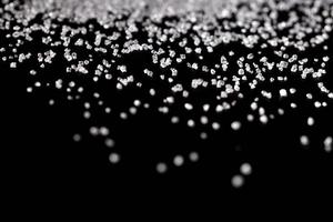 Azúcar de cristal blanco sobre fondo negro foto