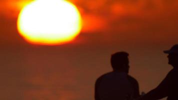 silhuett av en man som tittar på solnedgången på stranden. video