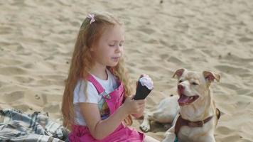 Girl eats ice cream and feeds the dog outdoors