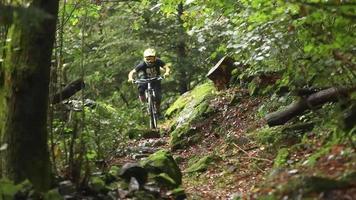 un uomo va in mountain bike in una foresta.