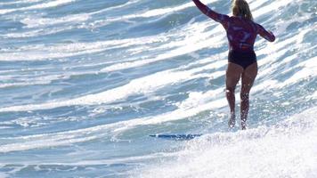 une jeune femme surfant sur une planche de surf longboard. video