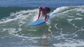 uma jovem surfando em uma prancha de surf longboard.
