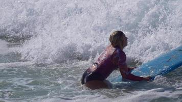uma jovem remando em uma prancha de surfe longboard.