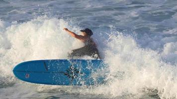 une jeune femme en combinaison de surf sur une planche de surf longboard. video