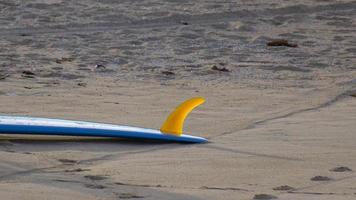 en blå longboard surfbräda på stranden. video