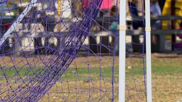 Details eines Netzes und eines Tors bei einem Fußballspiel.