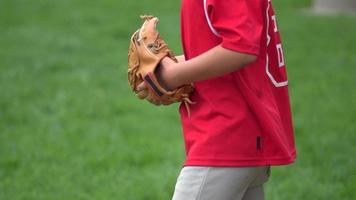 en pojke övar att spela fångst på ett litet basebollfält. video