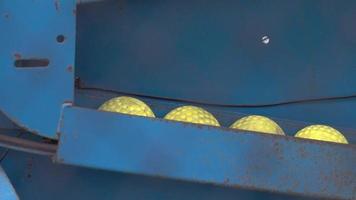 Detalles de una máquina de lanzamiento vintage cargada con pelotas de béisbol amarillas. video