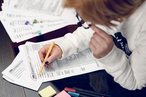 Woman fills the tax form, working with tax documents. Form 1040 Individual Income Tax return form. United States Tax forms. American blank tax forms. Tax time. photo