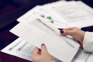 Woman fills the tax form, working with tax documents. Form 1040 Individual Income Tax return form. United States Tax forms. American blank tax forms. Tax time. photo