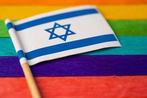 Isarael flag on rainbow background symbol of LGBT gay pride month  social movement rainbow flag is a symbol of lesbian, gay, bisexual, transgender, human rights, tolerance and peace. photo