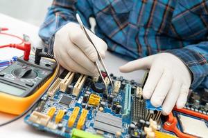 technician repairing inside of hard disk by soldering iron. Integrated Circuit. the concept of data, hardware, technician and technology. photo