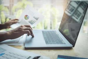 Businessman using calculator to review balance sheet photo