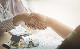Los agentes inmobiliarios acuerdan comprar una casa y entregar las llaves a los clientes.