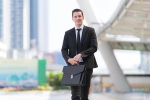 Successful businessman going on business meeting holding briefcase photo