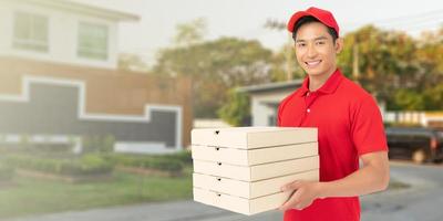 Delivery man employee in red t-shirt uniform face mask holding empty cardboard box photo