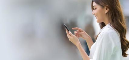 retrato al aire libre de mujer joven feliz usando un teléfono foto