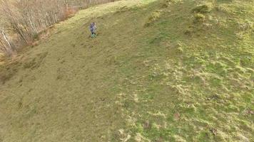 veduta aerea di un trail runner che corre su un sentiero di montagna con colori autunnali.